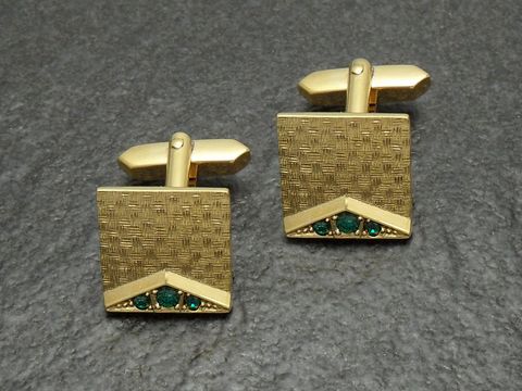 Vergoldete Manschettenknöpfe mit grün funkelndem Strass, Hersteller Juwelier Harnisch, goldfarbenes Design mit geometrischem Muster und eleganter Akzentuierung.