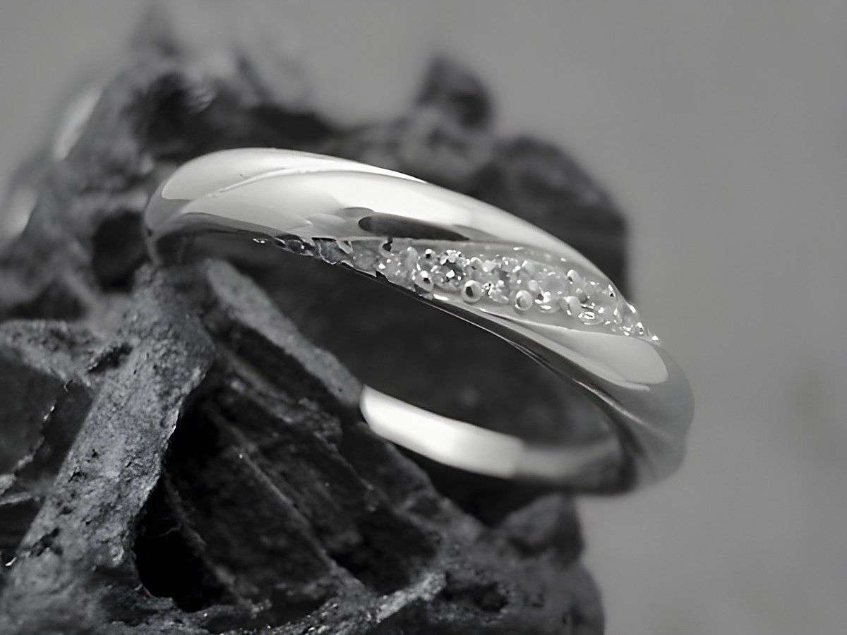 Silber Ring Wellig aus Sterling Silber rhodiniert mit Zirkonia, Größe 64, Hersteller Juwelier Harnisch, über Größe 60 / 19,1, elegant und glänzend, auf einer dunklen Struktur präsentiert.