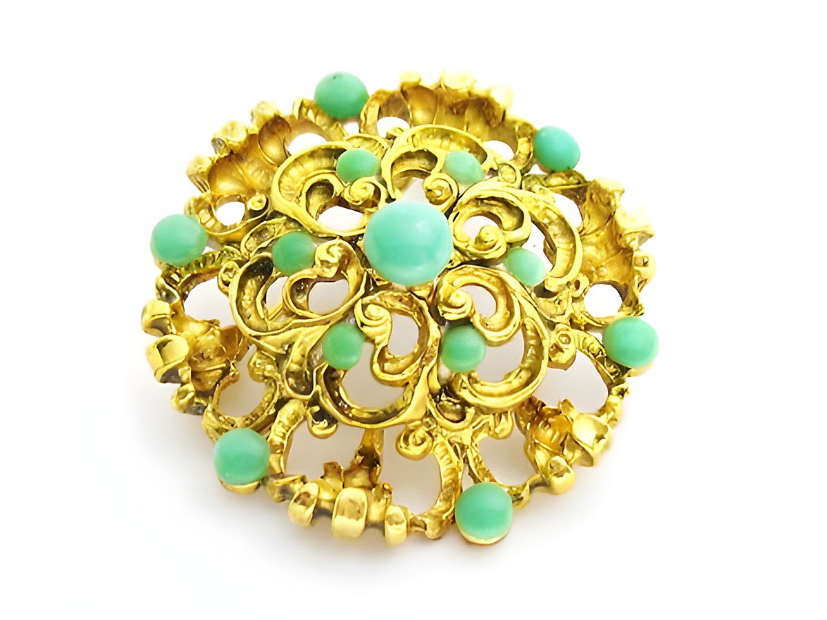 Brosche im Sexy City Look in türkisfarbig rund, mit filigranem goldfarbenem Design und verschiedenen türkisfarbenen Steinen, Hersteller Juwelier Harnisch, Broschen Türkis Look.