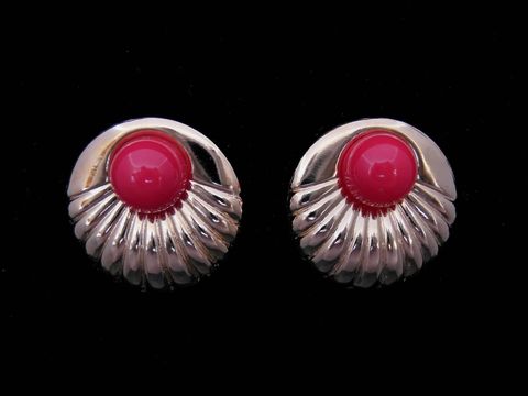 Runde, goldfarbene Ohrringe mit roten, modischen Akzenten, hergestellt von Juwelier Harnisch, ideal für jeden Anlass und passend zu verschiedenen Outfits.