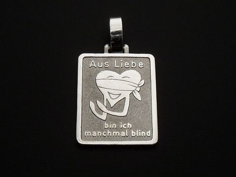 Silber Anhänger mit der Gravur Aus Liebe bin ich manchmal blind, kombiniert mit einem lustigen Herzmotiv, Hersteller Juwelier Harnisch. Ideal für liebevolle Geschenke.