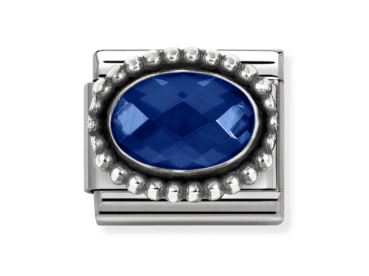 Zierschmuck von Nomination mit einem ovalen, blauen Zirkonia, umgeben von einem strukturierten Rand aus Sterling Silber. Elegantes und farbenfrohes Design, ideal für jeden Anlass.