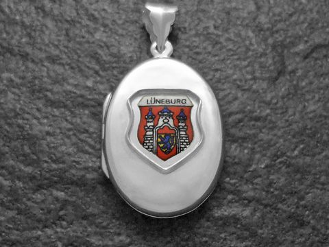 Silbernes Medaillon mit dem Wappen von Lüneburg, Deutschland, in farbiger Darstellung. Das Wappen zeigt eine stilisierte Burg und ist auf einer ovalen Fläche angebracht. Hersteller ist Juwelier Harnisch aus Niedersachsen.