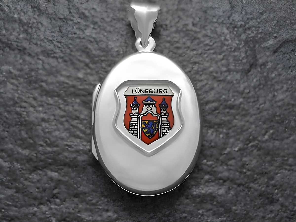Silbernes Medaillon mit dem Wappen von Lüneburg, Deutschland, in farbiger Darstellung. Das Wappen zeigt eine stilisierte Burg und ist auf einer ovalen Fläche angebracht. Hersteller ist Juwelier Harnisch aus Niedersachsen.