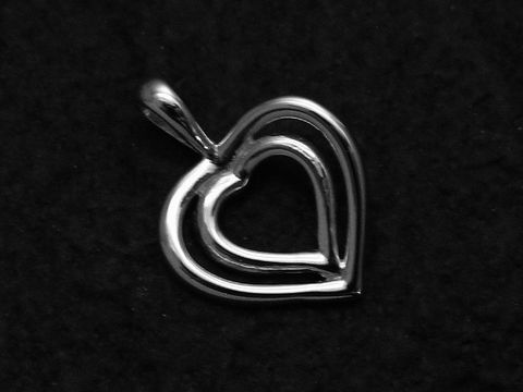 Anhänger Herz in Herz aus 925 Sterling Silber, flach gestaltet, mit feinem Detail und glänzender Oberfläche, Hersteller Juwelier Harnisch. Perfekt als Schmuckstück für besondere Anlässe.