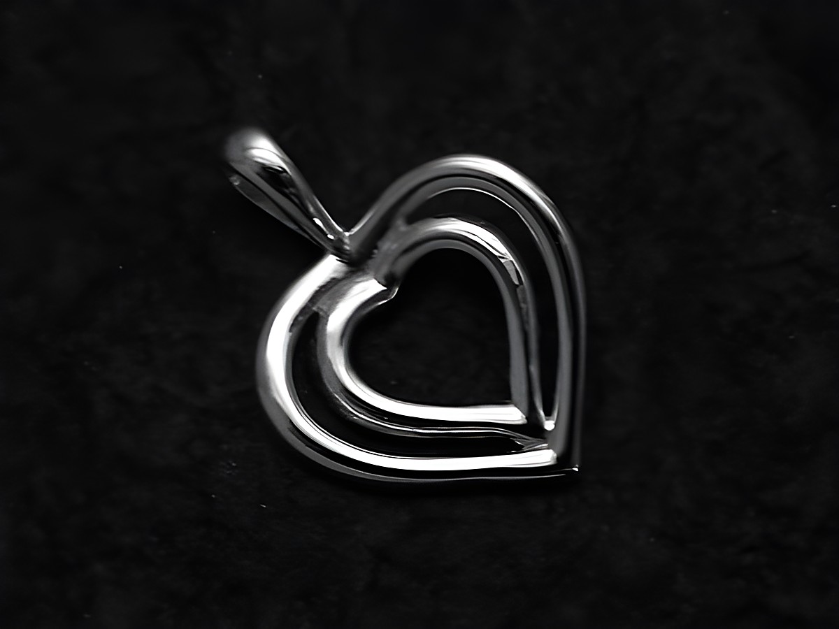 Anhänger Herz in Herz aus 925 Sterling Silber, flach gestaltet, mit feinem Detail und glänzender Oberfläche, Hersteller Juwelier Harnisch. Perfekt als Schmuckstück für besondere Anlässe.