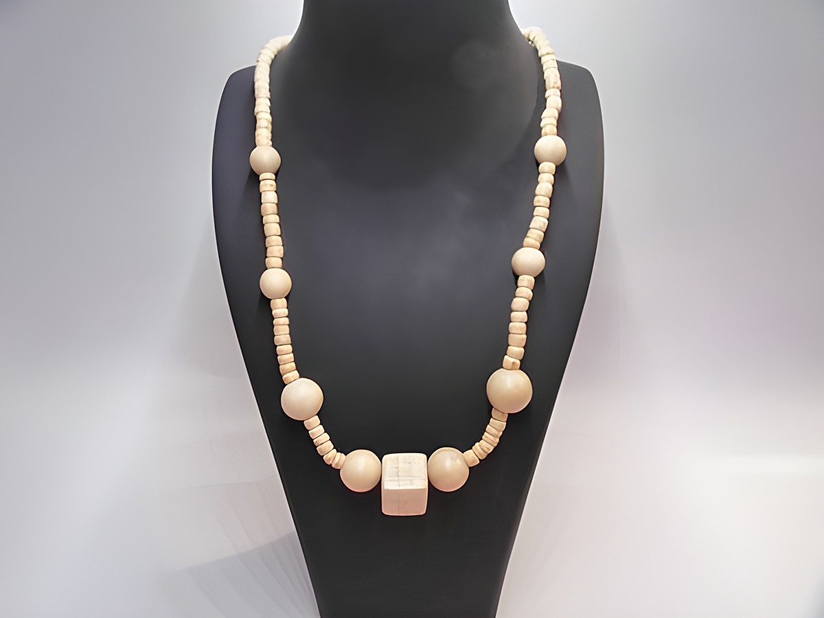 Holzkette Multiform 45 mm naturbraun 60 cm Holz Schmuck von Juwelier Harnisch, präsentiert auf einem schwarzen Halter, besteht aus verschiedenen naturbraunen Holzperlen.