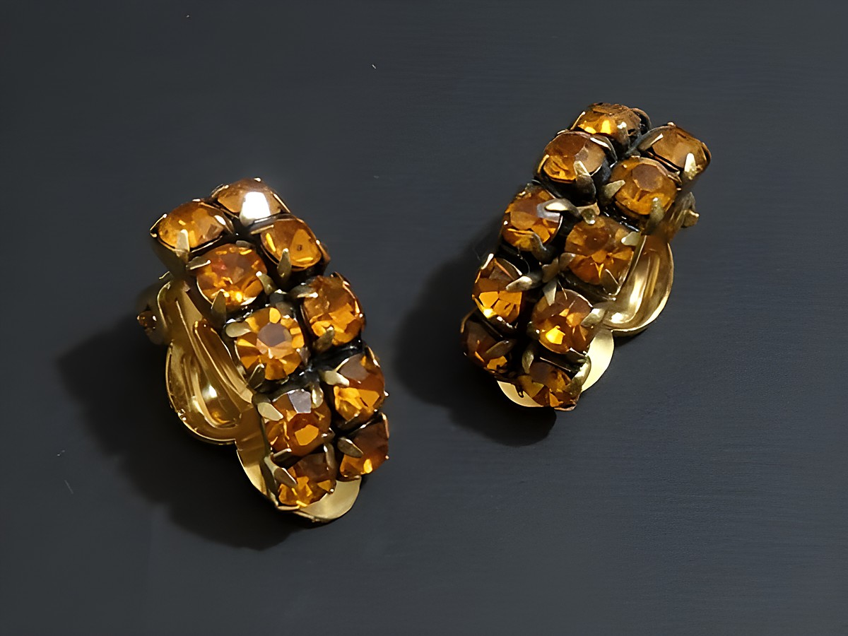 Strass Ohrclips in galantem Design mit orangefarbenen, funkelnden Steinen und goldfarbener Fassung, Hersteller Juwelier Harnisch, ideal für elegante Anlässe.