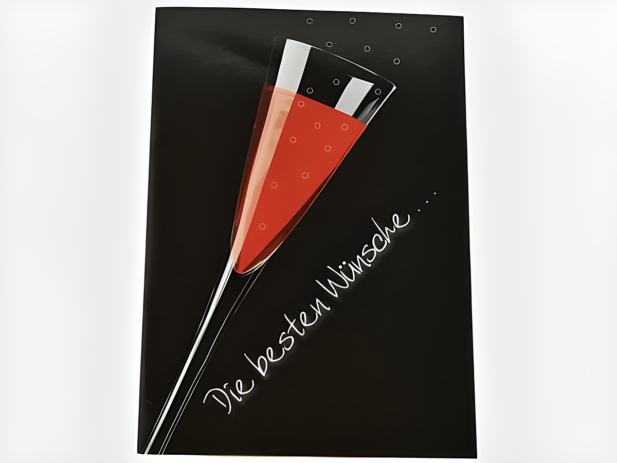 Eine Geburtstagskarte mit einem Sektglas, gefüllt mit rotem Inhalt, auf schwarzem Hintergrund. Hersteller ist Juwelier Harnisch. Die Karte enthält den Schriftzug Die besten Wünsche.