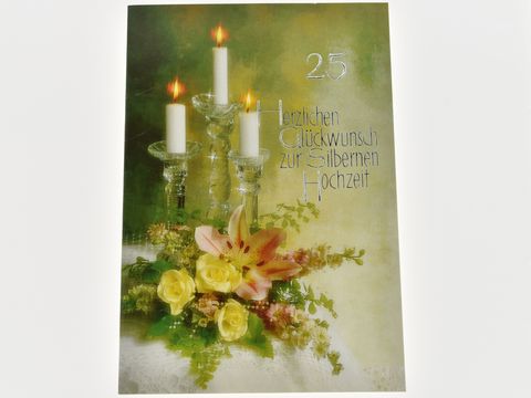 Eine Hochzeitskarte mit einem eleganten Kerzenleuchter, der drei brennende Kerzen trägt, umgeben von frischen Blumen in sanften Farben. Hersteller: Juwelier Harnisch, Hochzeitskarten.