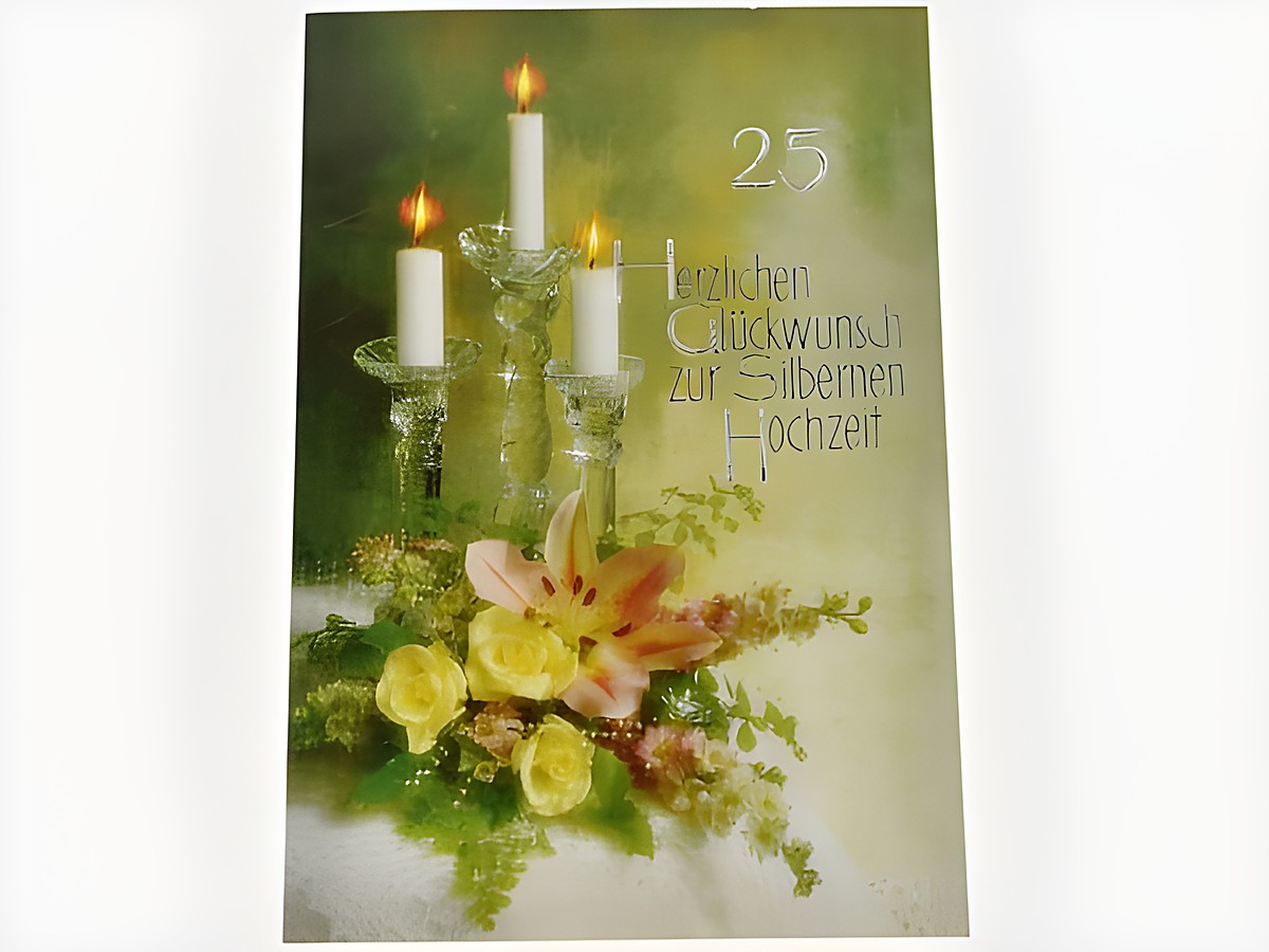 Eine Hochzeitskarte mit einem eleganten Kerzenleuchter, der drei brennende Kerzen trägt, umgeben von frischen Blumen in sanften Farben. Hersteller: Juwelier Harnisch, Hochzeitskarten.