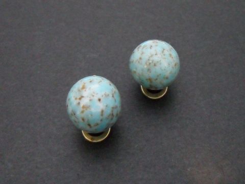 71809-0 Ohrclip in zeitlosem Design aus türkisfarbenem Synthmaterial mit goldfarbenen Elementen, Hersteller Juwelier Harnisch, perfekt für stilvolle Akzente.