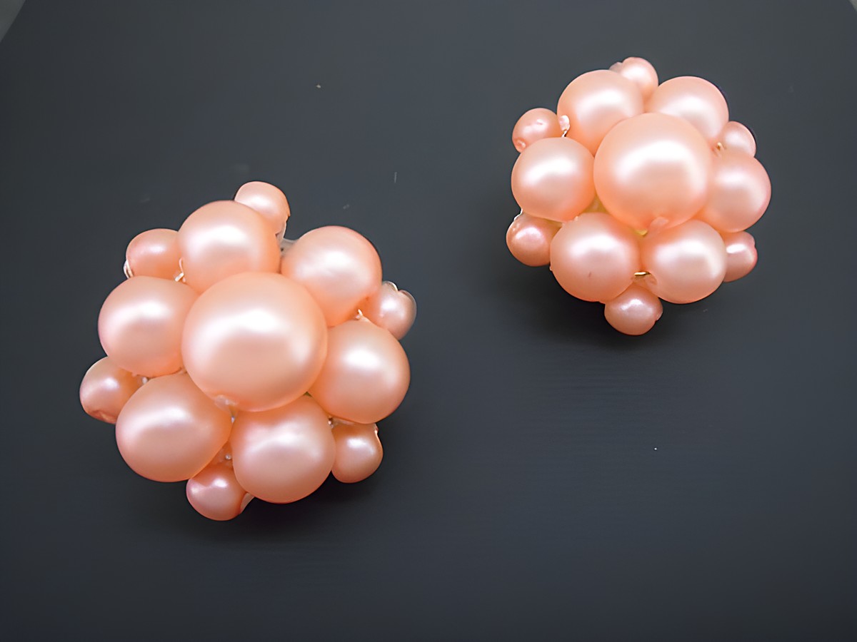 Rosa blumige Ohrclips aus goldfarbenem Material mit seidenmatten synthetischen Zuchtperlen, hergestellt von Juwelier Harnisch. Ideal für elegante Anlässe.
