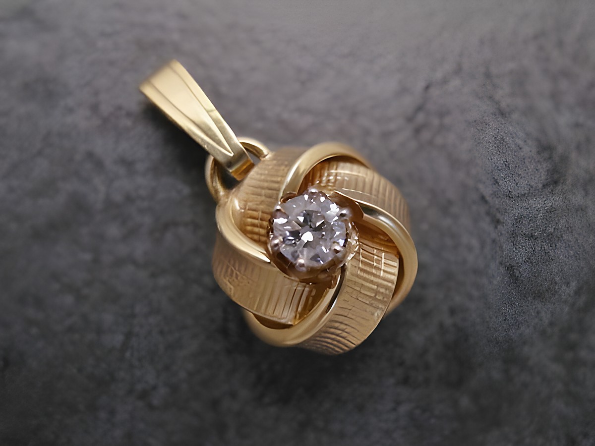 Designorientierter Anhänger aus Gelbgold 585, verschlungenes Muster mit einem Brillanten in der Mitte, gefertigt von Juwelier Harnisch, ideal für elegante Anlässe.