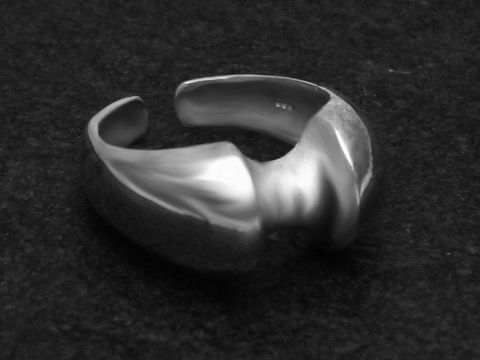 Silberring DESIGN Größe wenig verstellbar, Hersteller Juwelier Harnisch, ohne Stein, elegant geformt und glänzend, auf dunklem Hintergrund präsentiert.