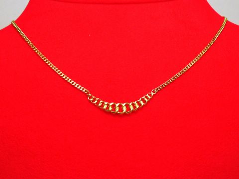 Collier Kette 333 Mittelteil Panzerkette Hingucker 39cm von Juwelier Harnisch präsentiert sich elegant auf rotem Untergrund, mit einem einzigartigen Design und glänzenden goldenen Gliedern.