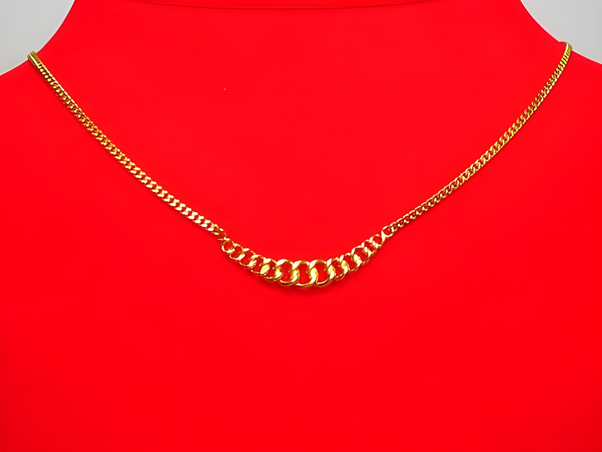 Collier Kette 333 Mittelteil Panzerkette Hingucker 39cm von Juwelier Harnisch präsentiert sich elegant auf rotem Untergrund, mit einem einzigartigen Design und glänzenden goldenen Gliedern.