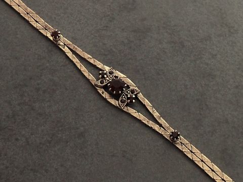 Strass Armband in prunkvollem Design, mit granatrot-farbigen Elementen, goldfarben, verstellbar von 19 bis 21 cm, hergestellt von Juwelier Harnisch, ideal für festliche Anlässe.