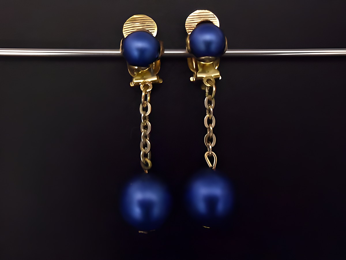 Ohrclip in blau matt mit zeitlosem Design, goldfarbene Elemente und Kunstharz, Hersteller Juwelier Harnisch, eleganter Schmuck.