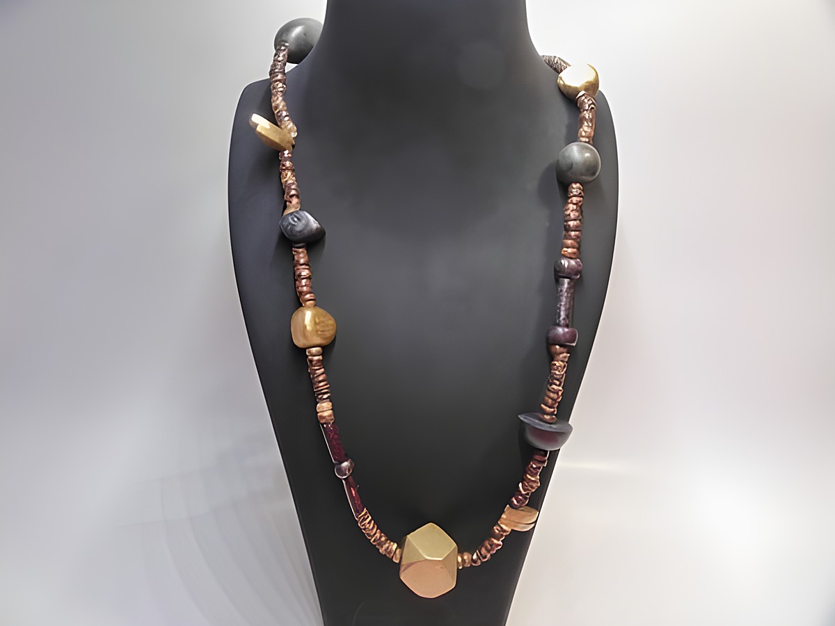 Holzkette Multiform 20 mm bunt 90 cm Holz Schmuck von Juwelier Harnisch, besteht aus verschiedenen bunten Holzperlen in unterschiedlichen Formen und ist auf einem schwarzen Halsständer präsentiert.