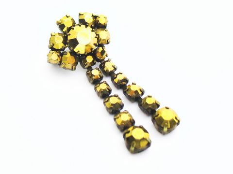 Goldige Strass Damen Brosche im sexy City Look im retro Stil. Hergestellt von Juwelier Harnisch, die Brosche leuchtet in Gelb und Braun und hat ein auffälliges Design mit funkelnden Steinen.