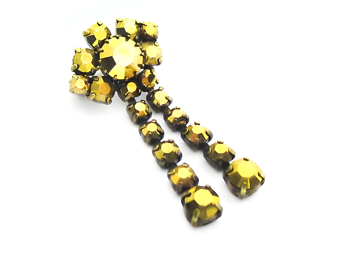 Goldige Strass Damen Brosche im sexy City Look im retro Stil. Hergestellt von Juwelier Harnisch, die Brosche leuchtet in Gelb und Braun und hat ein auffälliges Design mit funkelnden Steinen.