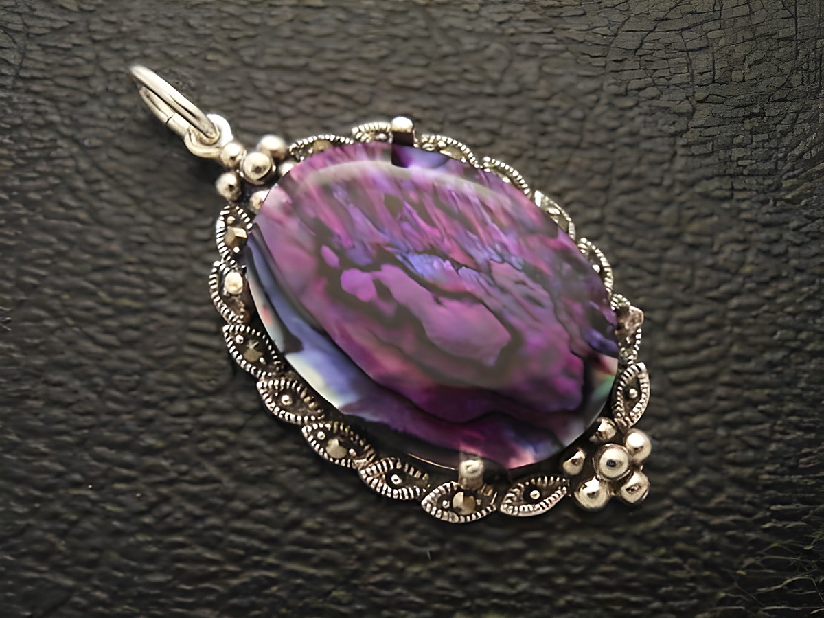 Cabochon Perlmutt in lila, eingefasst in einem kunstvollen Silber Medaillon Anhänger vom Hersteller Juwelier Harnisch, ideal für dezente Eleganz in Schmuckdesign.