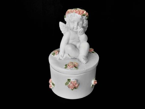 Eine dekorative Dose mit einem sitzenden Schutzengel und einer Rosenkranz-Fassung, umgeben von zarten Rosenverzierungen, ideal als Geschenkidee des Juweliers Harnisch.