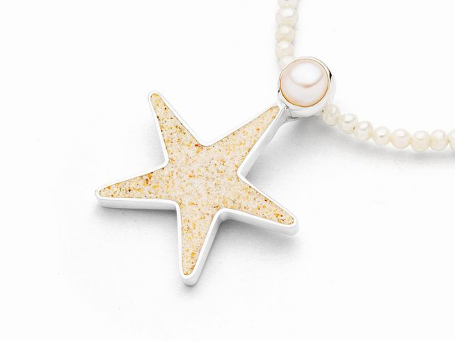 Der Anhänger zeigt einen rhodinierten Sterlingsilber Sandseestern mit Strandsand, ergänzt durch eine Perle. Ideal für einen eleganten Look.