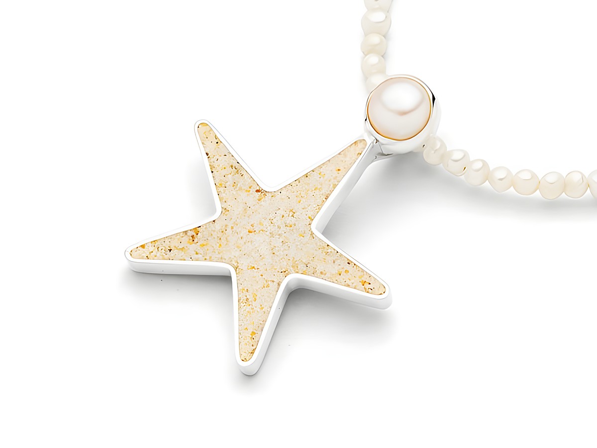 Der Anhänger zeigt einen rhodinierten Sterlingsilber Sandseestern mit Strandsand, ergänzt durch eine Perle. Ideal für einen eleganten Look.