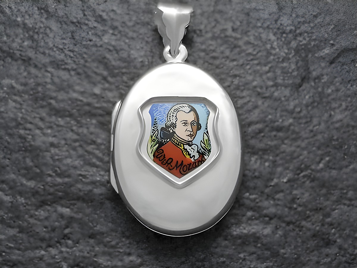 Silbermedaillon mit einer Darstellung von Wolfgang Amadeus Mozart im roten Outfit, umgeben von dekorativen Elementen. Hergestellt von Juwelier Harnisch, Europa Medaillons.