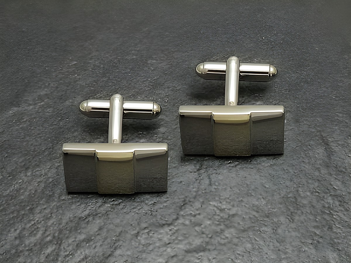 Moderne Bi-Color Designer Manschettenknöpfe von Juwelier Harnisch in silberfarben, stilvolles und elegantes Design mit glatten Oberflächen und klaren Linien, perfekt für besondere Anlässe.