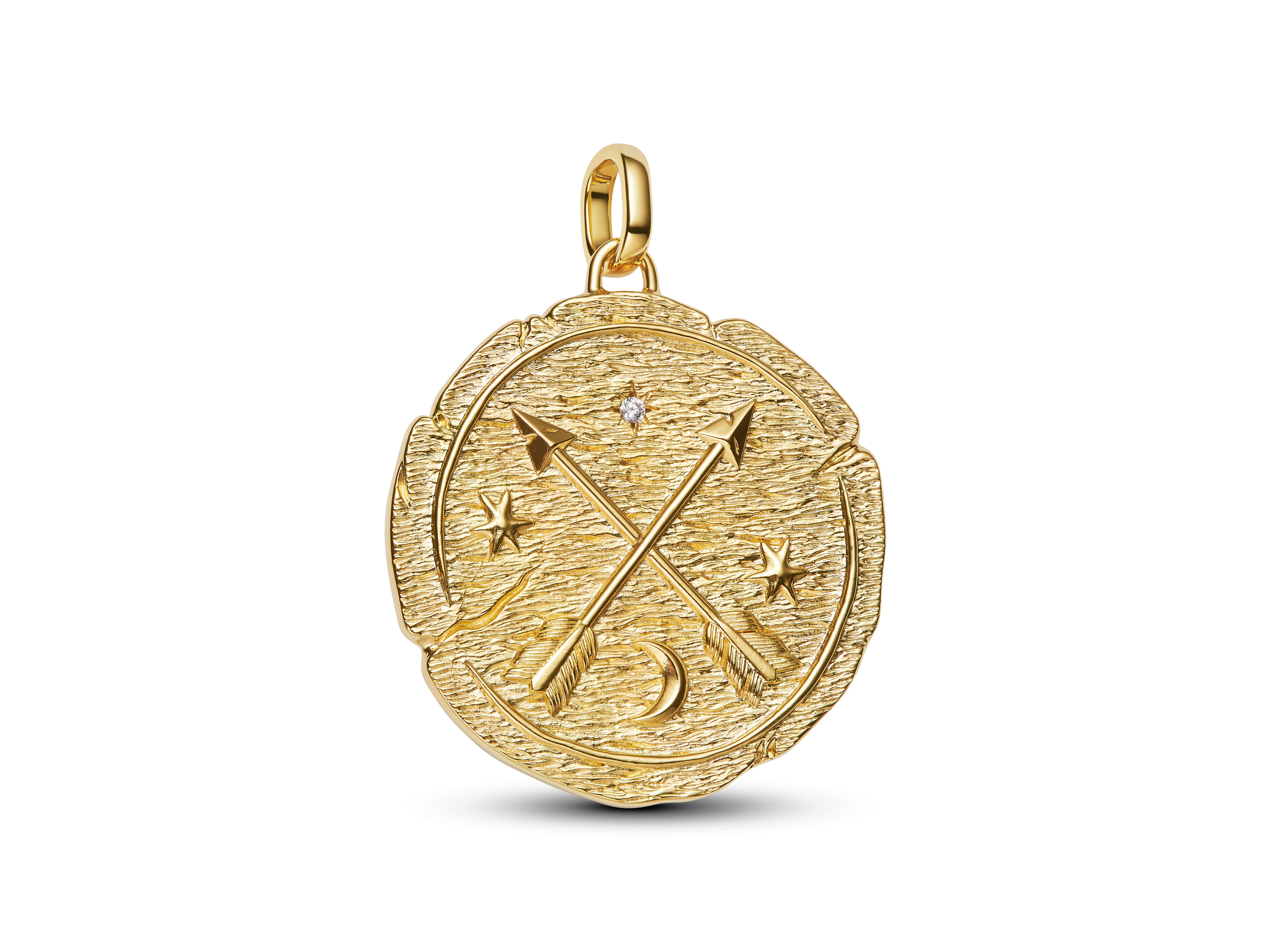 Gekreuzte Pfeile auf einem großen Medaillon-Charm aus gelbgold vergoldetem Material, verziert mit Zirkonia und einem Muster von Sternen und einem Halbmond, gefertigt von Pandora.
