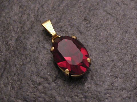Roter Strass Anhänger im sexy City Look in ovaler Form, gefertigt von Juwelier Harnisch, ideal für stilvolle Akzente und glamouröse Outfits.