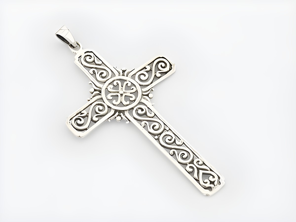 Ein Anhänger in Form eines Kreuzes aus Sterling Silber mit einem kunstvollen Muster, hergestellt von Juwelier Harnisch.