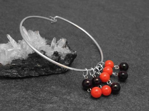 Silber Armreifen retro 1,6 mm 17 cm von Juwelier Harnisch, mit bunten Kugeln in Rot und Schwarz, präsentiert auf schwarzem Untergrund mit Kristall.