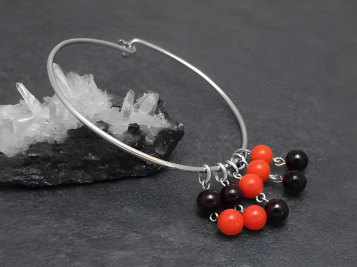 Silber Armreifen retro 1,6 mm 17 cm von Juwelier Harnisch, mit bunten Kugeln in Rot und Schwarz, präsentiert auf schwarzem Untergrund mit Kristall.