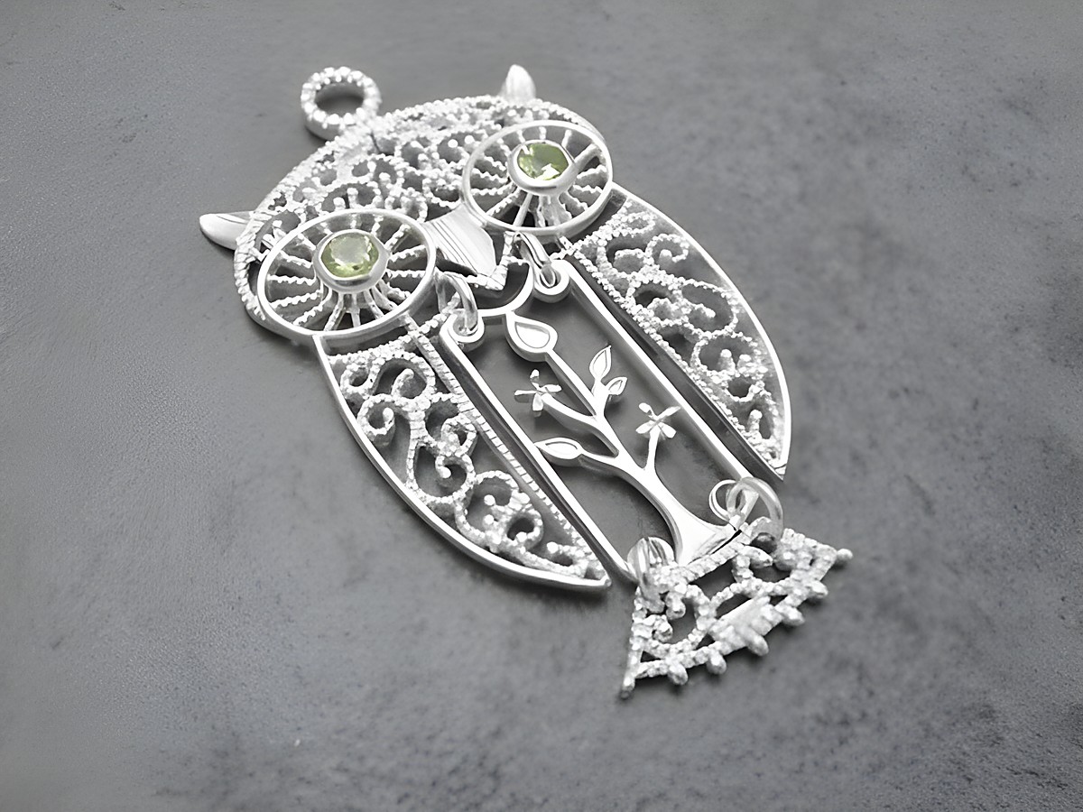 Silber Anhänger in Form einer Eule mit beweglichem Element und Peridot-Steinen, von Juwelier Harnisch, als Glücksbringer gestaltet, ideal für Tierliebhaber.