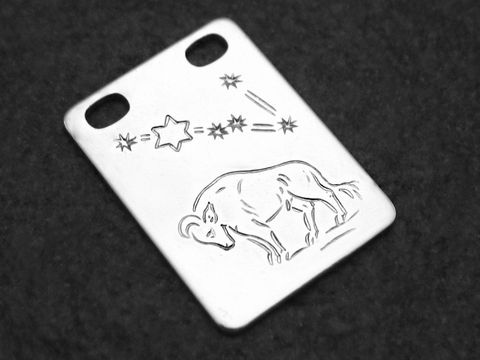 Eckige Gravurplatte aus Silber mit dem Sternzeichen Stier. Auf der Platte ist ein Stier abgebildet, umgeben von einem Silberstern und weiteren Sternen. Hersteller: Juwelier Harnisch.