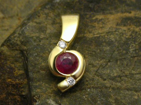 Eleganter Anhänger aus 585 Gold, verziert mit einem roten Rubin und zwei funkelnden Diamanten, hergestellt von Juwelier Harnisch. Stilvolles Design für besondere Anlässe.