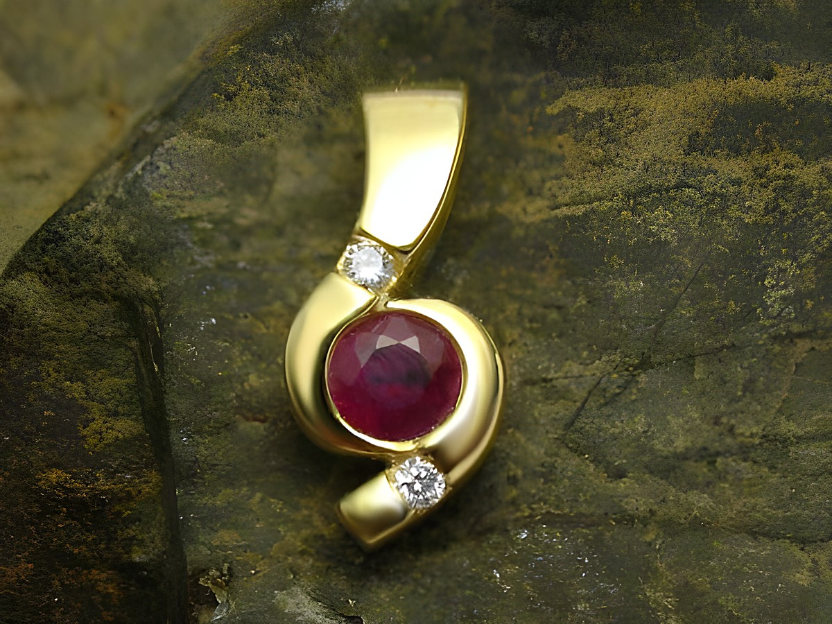 Eleganter Anhänger aus 585 Gold, verziert mit einem roten Rubin und zwei funkelnden Diamanten, hergestellt von Juwelier Harnisch. Stilvolles Design für besondere Anlässe.