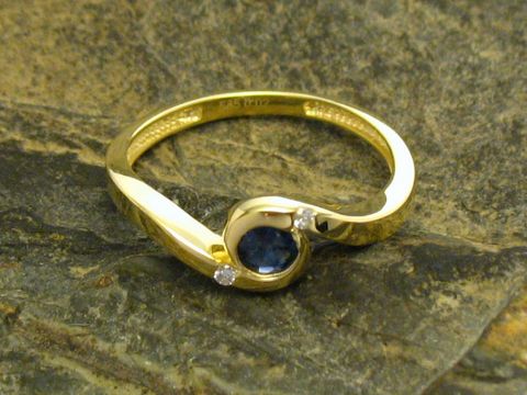 Goldring 585 mit Diamant und Saphir, Hersteller Juwelier Harnisch, Größe 56/18, elegantes Design mit geschwungener Form und farbigen Edelsteinen auf natürlichem Steinhintergrund.