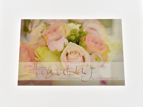 Hochzeitskarte mit rosafarbenem Strauß aus zarten Rosen und grünen Akzenten, beschriftet mit "Zum Hochzeitstag" und "Herzlichen Glückwunsch", Hersteller Juwelier Harnisch.