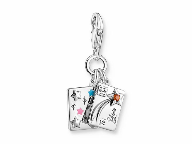 Charm-Anhänger von Thomas Sabo mit dem Motiv Make a wish, aus geschwärztem Silber, Emaille in Farben und Zirkonia-Details, gestaltet als Briefumschlag mit Sternen und einem Zauberstab.