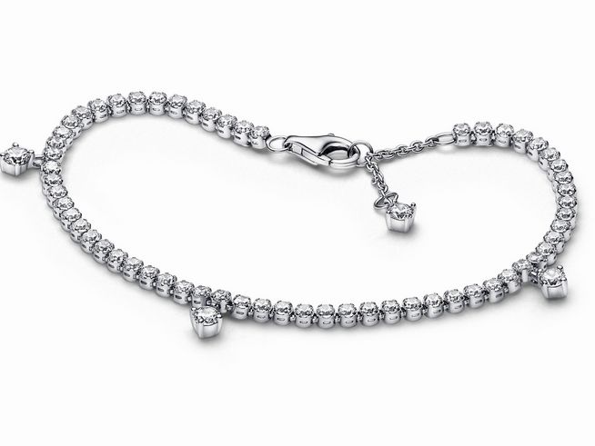 Ein elegantes Pandora Armband aus Sterling Silber mit funkelnden klaren Zirkonia-Steinen in einer Tennisarmband-Optik, versehen mit charmanten Details und einem sicheren Verschluss.