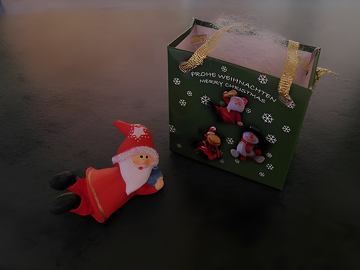 Weihnachtsmann mit Geschenktasche liegend mit Geschenk, Hersteller: Juwelier Harnisch, Weihnachten.