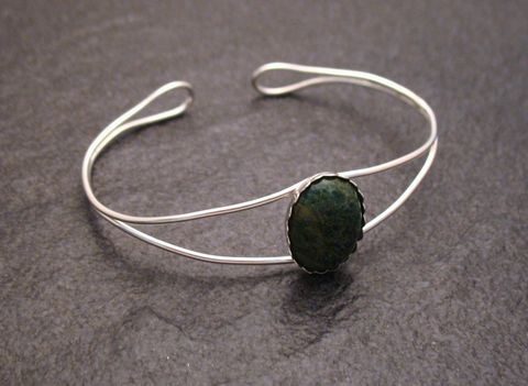 Ein schmaler Armreifen aus Sterling Silber mit einem ovalen Afrika Jade Cabochon im Zentrum, Umfang 17 cm, gefertigt von Juwelier Harnisch.