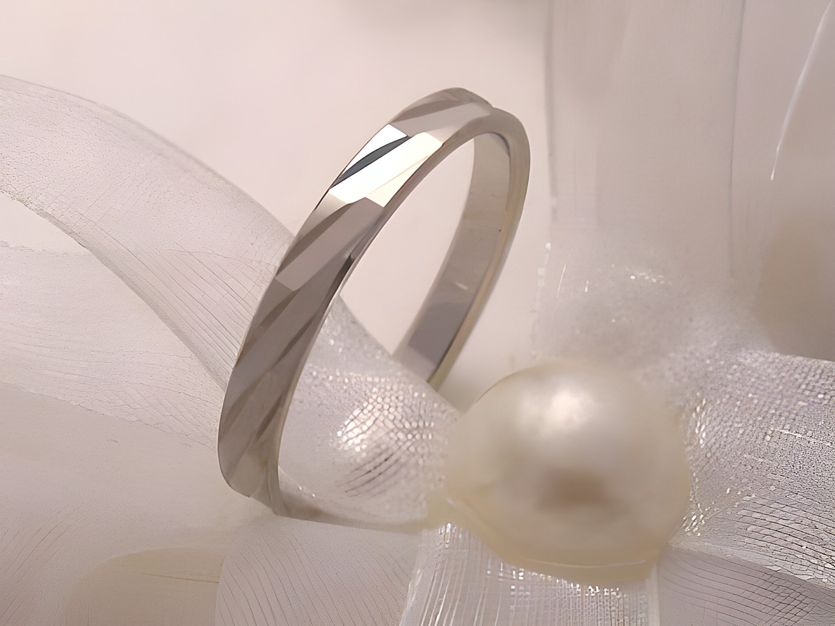 Trauring Ehering WHITE CHARME aus Weißgold 333 in Größe 64/20,4 von Juwelier Harnisch auf zarter Dekoration mit Perle präsentiert.