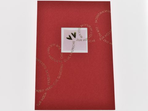 Rote Hochzeitskarte mit goldener Schrift und dekorativen Elementen, Hersteller Juwelier Harnisch, ideal für Glückwünsche zur Hochzeit.