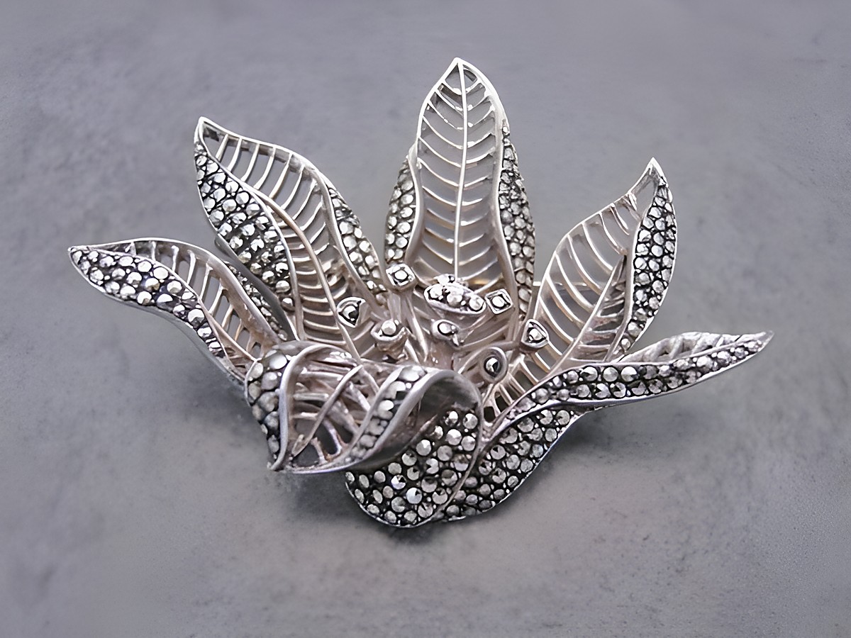 Silber Brosche in Blumenform mit filigranen Blättern, verziert mit Markasit. Hersteller Juwelier Harnisch, ideal für Natur-Liebhaber. Elegantes Schmuckstück für jeden Anlass.
